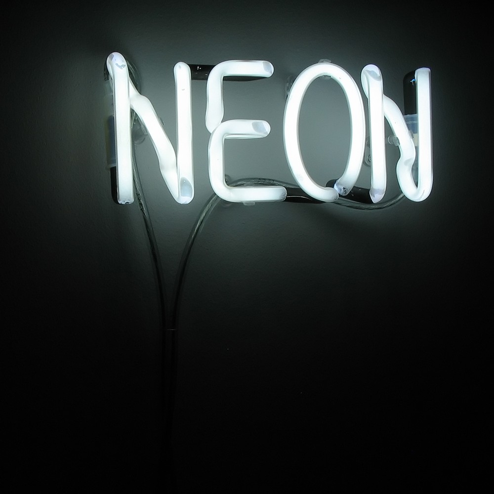 The image shows a neon sign with the word 